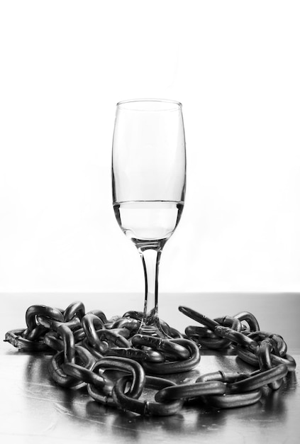 Wine glass with chains on white background