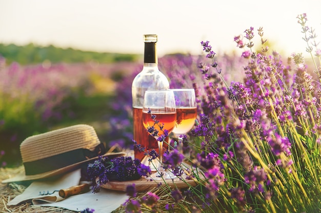 Wine in glasses. Picnic in the lavender field. Selective focus. Nature.