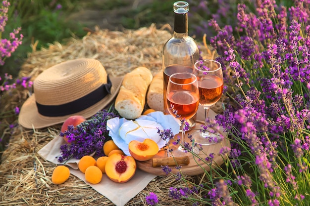 Wine in glasses. Picnic in the lavender field. Selective focus. Nature.