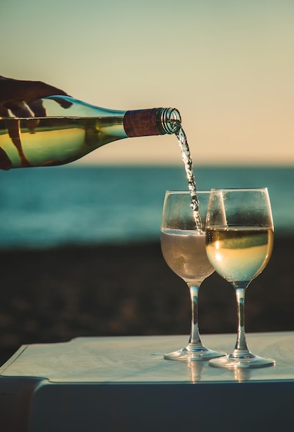 Wine glasses at sunset on the beach. Selective focus.