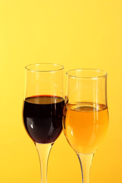 Wine in glasses on yellow background