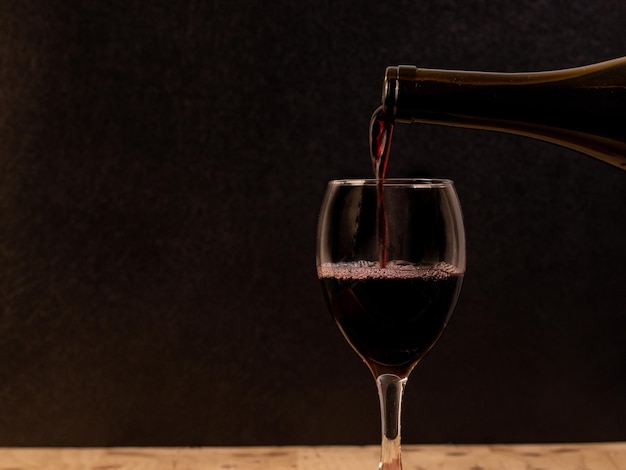 The wine is born from the grape, photography on black background and wooden table