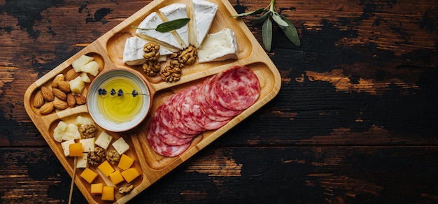 Wine snacks assorted cheese on a wooden board