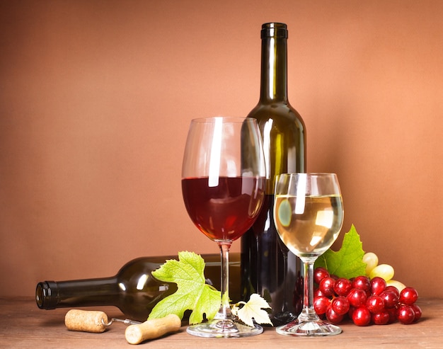 Wine still life: bottles, corks, grapes and glasses