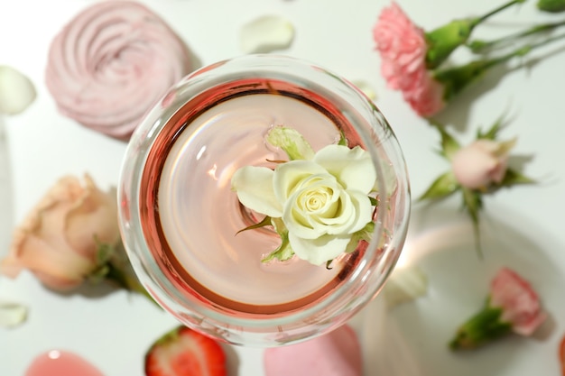 Wine, sweet food and flowers on white table