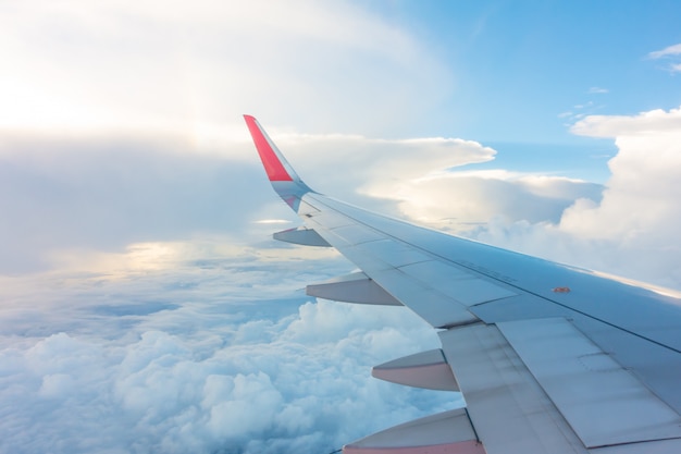 Wing of an airplane flying above the clouds