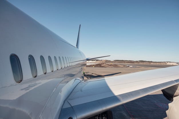 Wing of airplane with windows on runway preparation for take off