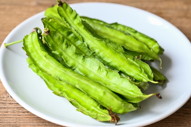 Winged Bean on white plate background Psophocarpus tetragonolobus Green winged or Four angle beans