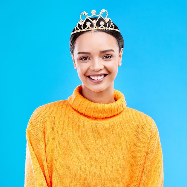 Winner crown and portrait of woman in studio for celebration princess and party Smile beauty and fashion with female and tiara on blue background excited for achievement winner and prom event