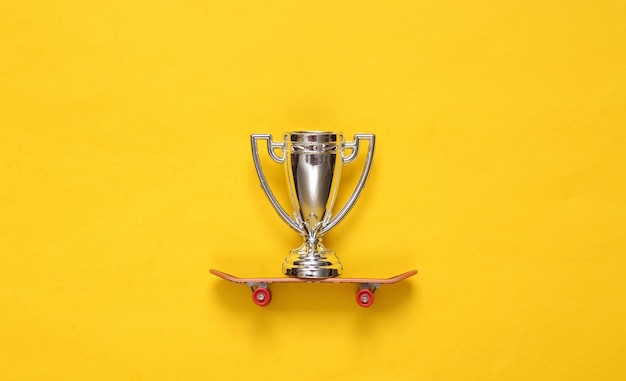 Winner cup on skateboard Yellow background