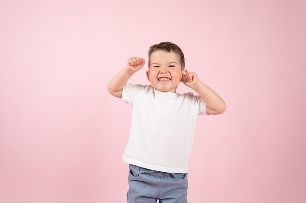 Winner kid isolated over pink background Boy shows how powerful he is High quality photo