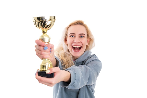 Winning competitions A young woman with a golden cup Selective focus on the cup Isolated