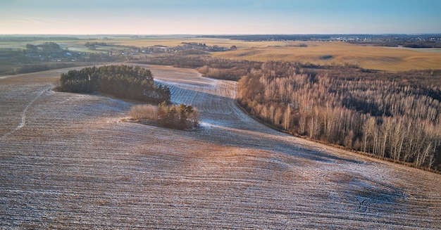 Winter Agricultural field under snow panorama. Aerial scene. December Rural landscape. Countryside top view. Minsk region, Belarus