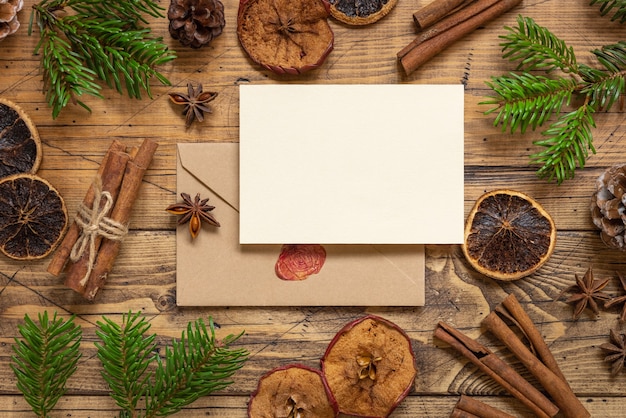 Winter Christmas Composition with a blank card and envelope on a wooden table flat lay