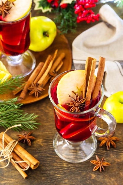 Winter Christmas hot drink with orange apple and spices Mulled wine in glass mug with spices