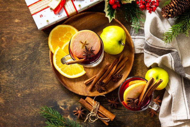 Winter Christmas hot drink with orange apple and spices Mulled wine in glass mug with spices