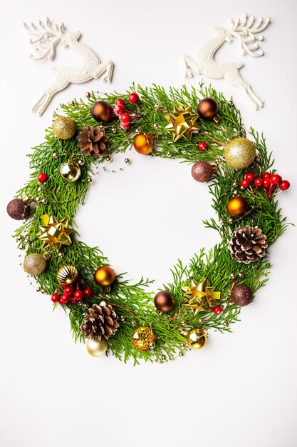 Winter and christmas wreath with gold christmas toys on white background