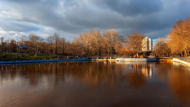 Winter city park with frozen lake cloudy sky beautiful evening light