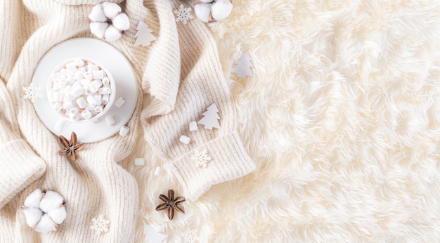 Winter composition on cream color knitted blanket and fluffy background.