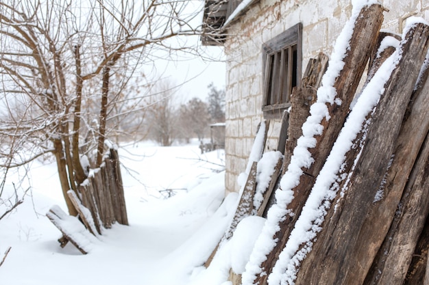 Winter countryside landscape, dilapidated abandoned ruined building covered in snow.