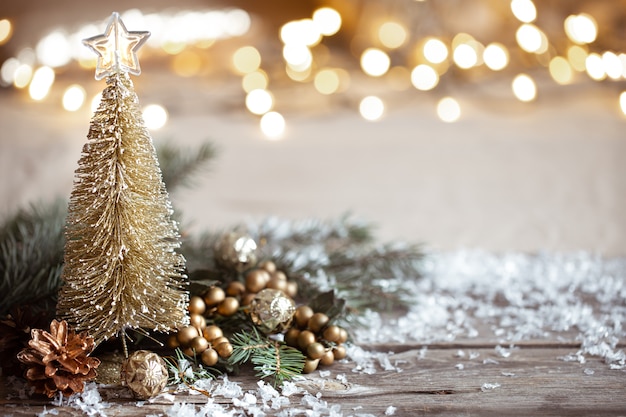 Winter cozy festive decor details, snow on a wooden table and bokeh.