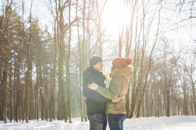 Winter, fashion, couple, christmas and people concept. smiling man and woman in winter park.