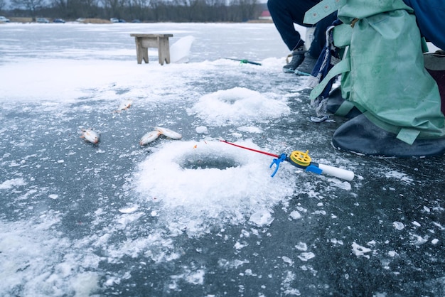 Winter fishing ice fishing ice hole and freshly caught fish lying on ice nearby