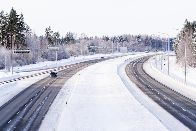 Winter highway Asphalt road through a snowy forest Car driving on a heavy winter road