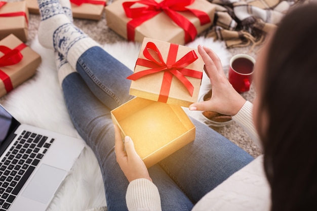 Winter holiday magic. Woman opening christmas present box at home