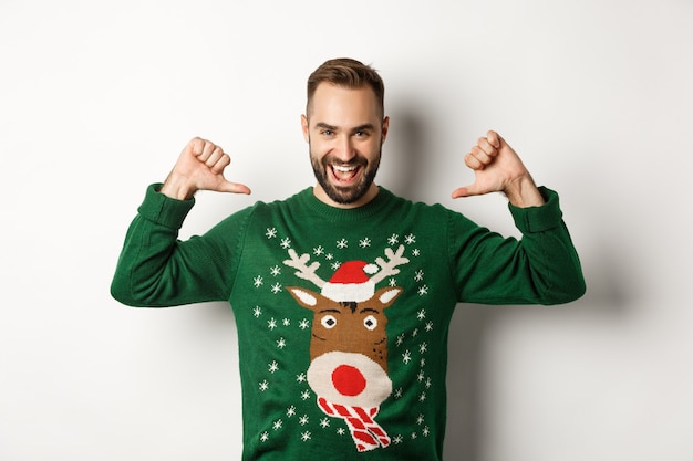 Winter holidays and christmas. Confident young man looking enthusiastic, pointing at himself proudly, standing over white background