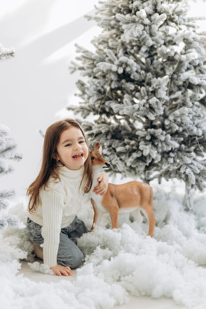 Winter holidays and people concept happy little girl near christmas tree at home