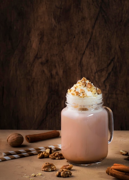 Winter hot dark chocolate with whipped cream and crushed walnuts in glass jar copy space