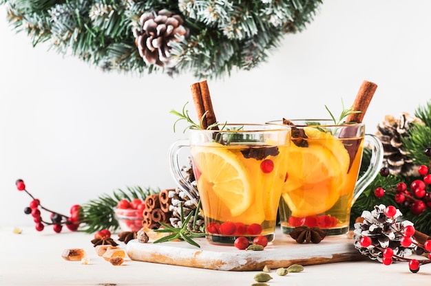 Winter hot tea with lemon cranberries herbs and spices for Christmas or New Year evening white background copy space selective focus