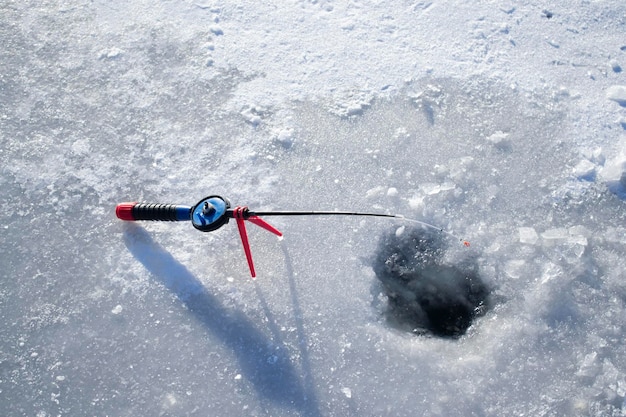 Winter ice fishing Ice fishing winter Fishing rod stands near hole in ice river