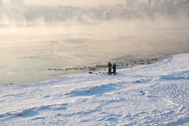 Winter landscape of fogy river in city.