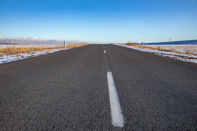 Winter landscape and ice-covered asphalt road