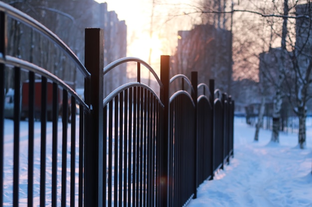 Winter landscape iron fence at sunset