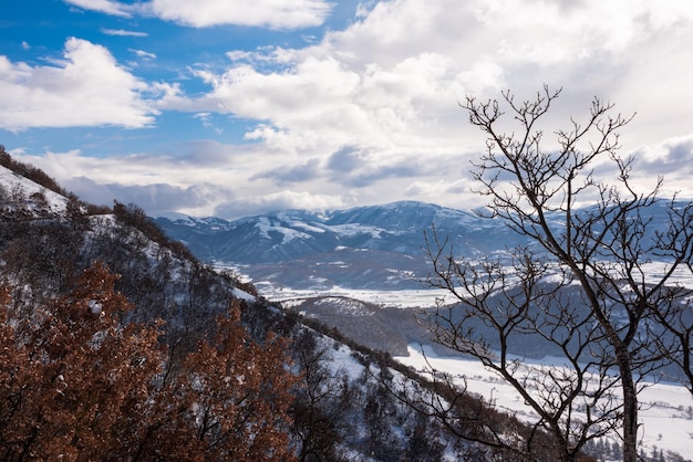 Winter landscape valley and hills covered with snow on bright sunny day