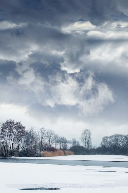 Photo winter landscape with dramatic cloudy sky over the river