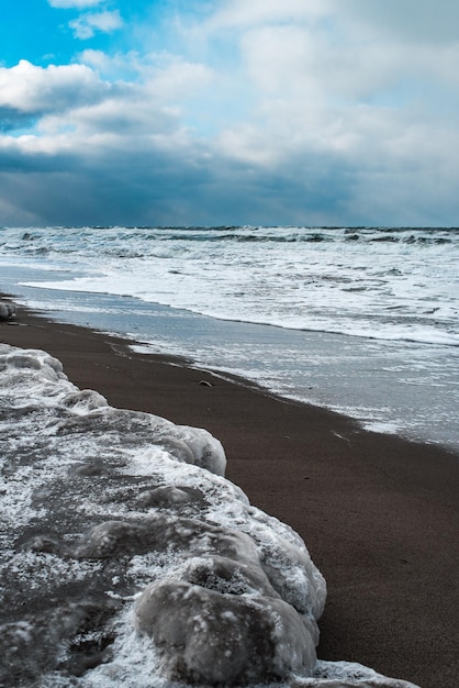 Winter landscape with frozen sea and icy beach Dramatic seascape Storm and snow weather