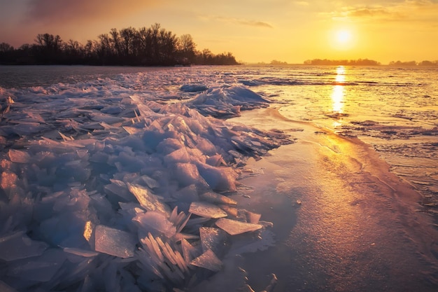 Winter landscape with sunset fiery sky and frozen icy sea coast Daybreak