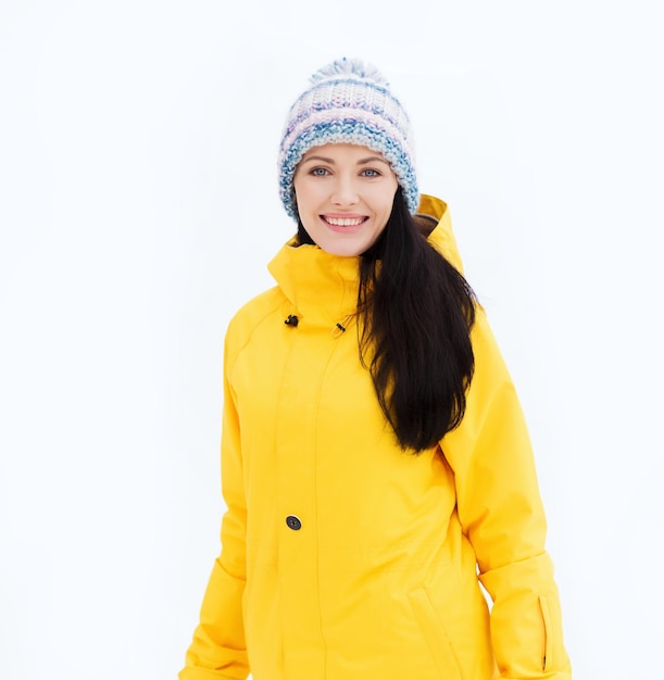 winter, leisure, clothing and people concept - happy young woman in winter clothes outdoors