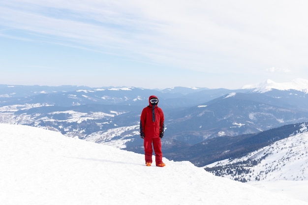 Winter, leisure, sport and people concept - Snowboarder stands on backcountry slope and holds snowboard. Ski concept