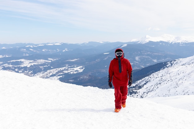 Winter, leisure, sport and people concept - Snowboarder stands on backcountry slope and holds snowboard. Ski concept