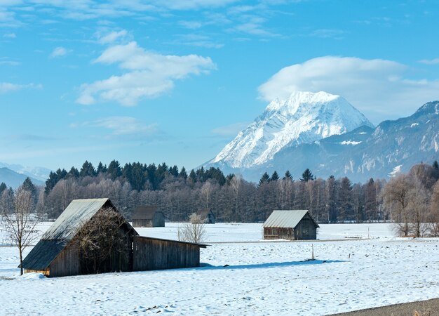 Winter mountain country landscape with wooden sheds, Austria