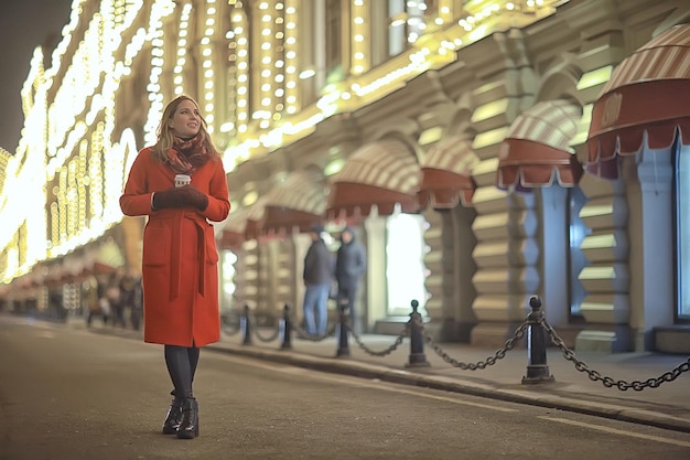 winter night in the city lights / adult girl in a coat walk in the city, fashionable stylish image of a beautiful model