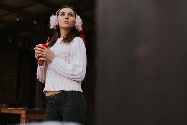 Winter portrait of beautiful woman holding a coffee to go outside on winter