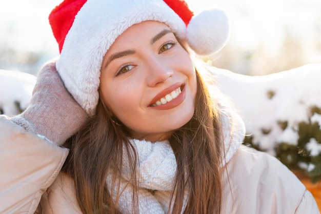 Winter portrait young adult beautiful woman in Santa hat Christmas mood Snowing Winter beauty fashion concept