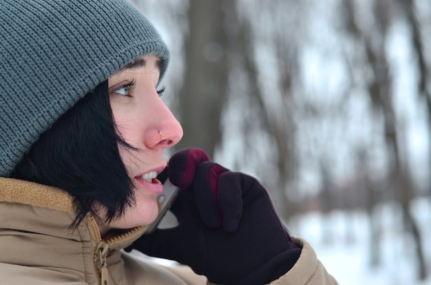 Winter portrait of young girl with smartphone