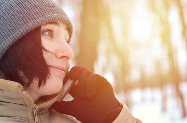 Winter portrait of young girl with smartphone